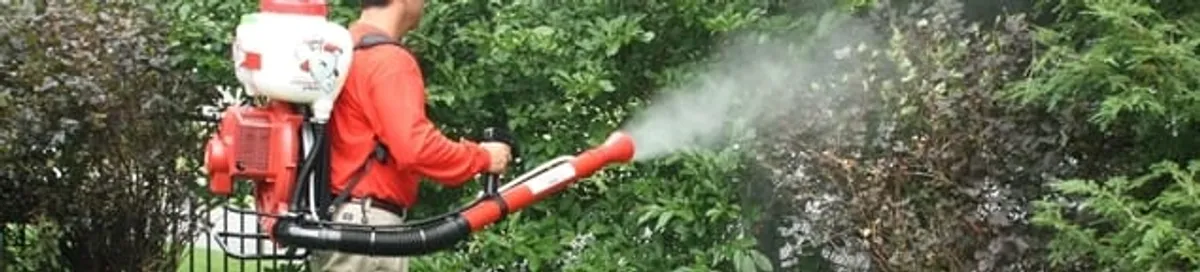 Mosquito control technician fogging shrubs and landscaping for mosquito treatment in Eugene, OR