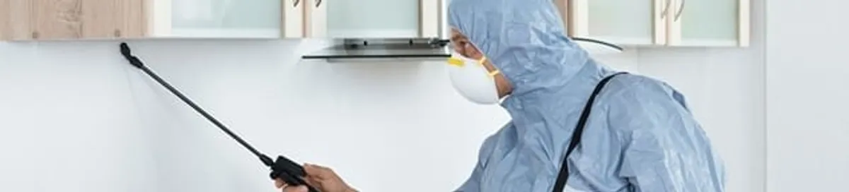 Termite treatment technician applying indoor pest control spray in Eugene, OR